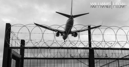 plane departing over barbed wires